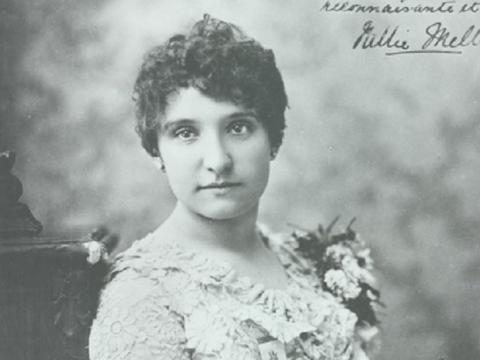Nellie Melba seated and holding a fan.