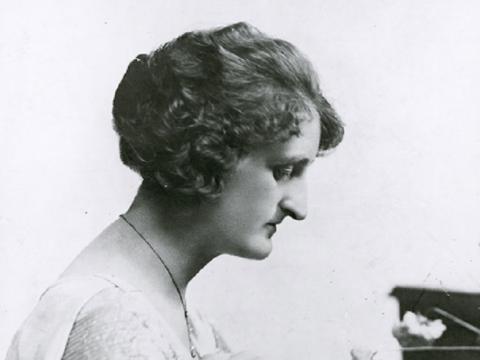 Una Bourne seated at a piano.