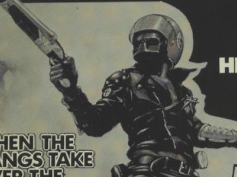 Advertisement for Mad Max showing motorcycle policeman holding a sawed-off shotgun.