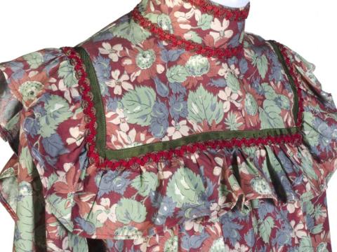 Detail of a colourful dress film costume in an early 1900s style with a flower-and-leaf motif