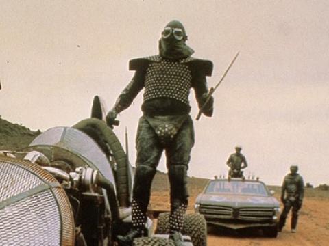 Marauder holding a weapon and standing on a futuristic car.