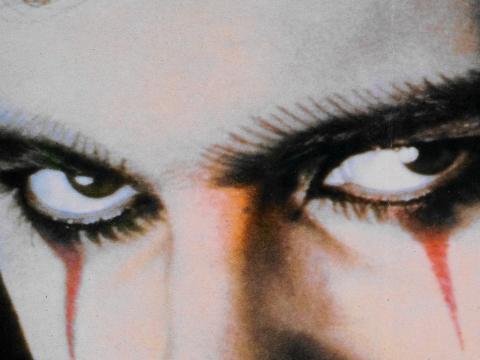Extreme close up of a menacing looking man's eyes with dark eye make up.