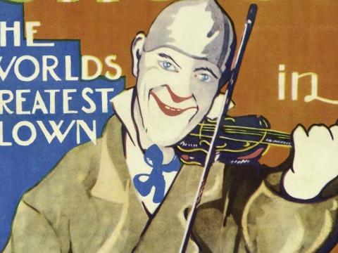 A close-up from a 1928 film poster of Grock the clown playing a fiddle