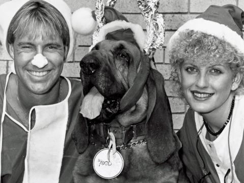 Brett Clements, Woodrow the Bloodhound and Edith Bliss. Brett and Edith are dressed in Santa suits and Woodrow is wearing reindeer antlers