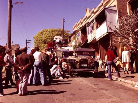 Crew filming vintage car in front of a terrace house on the streets of Sydney for Caddie.