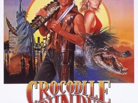 Australian poster for Crocodile Dundee showing illustrations of Mick Dundee, Sue Charlton and a crocodile with the outback and the New York City skyline as backgrounds