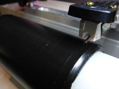 Close up of stylus on a black wax cylinder during the digitisation process.
