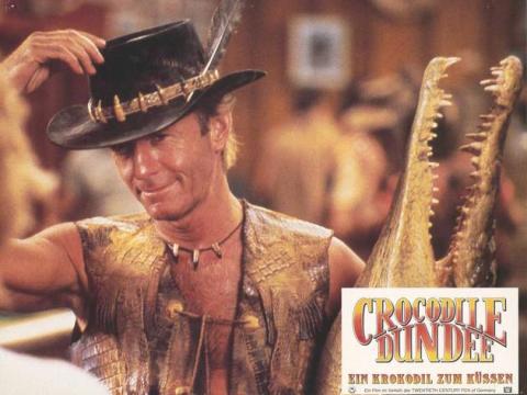 Lobby card depicting Mick 'Crocodile' Dundee holding a taxidermied crocodile