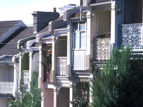 A row of houses in Sydney, all displaying balconies made of ironwork 