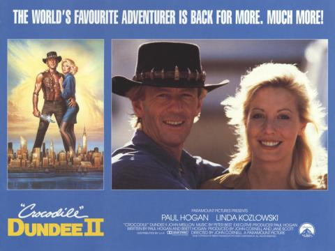 A lobby card for Crocodile Dundee II. The tagline says 'The world's favourite adventurer is back for more. Much more!'. There are two pictures of Paul Hogan (Mick Dundee) and Linda Kozlowski (Sue Charlton) and production company, cast and crew information