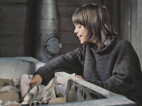 Greg Rowe as Storm Boy looking after baby pelicans who are sitting in an old bath tub in a scene from Storm Boy