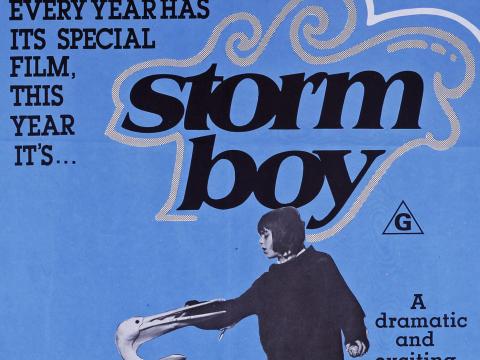 Australian poster for Storm Boy showing Greg Rowe with Mr Percival with his beak around Storm Boy's hand. Text reads 'every year has its special film. This year it's... Storm Boy'. Pictures of the main actors sit below.