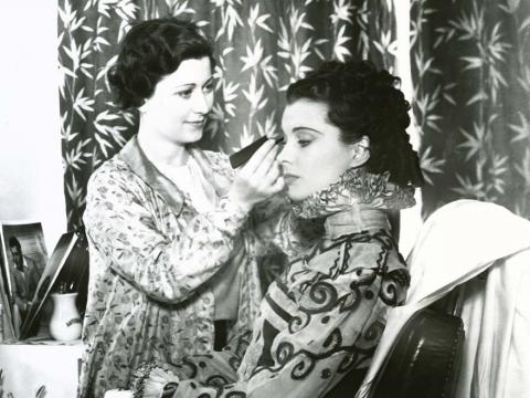 A woman applies make-up to Vivien Leigh during the filming of Fire Over England in 1937