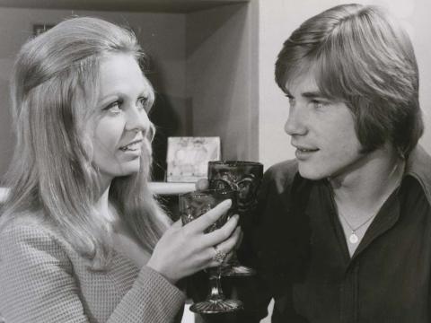 Jacki Weaver and Buddy England raise glasses in a 1970 episode of Australian detective show Homicide