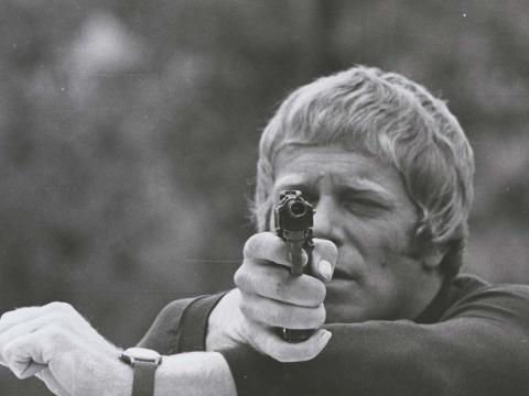 Jack Thompson points a gun at the camera in a 1970 episode of detective show Homicide