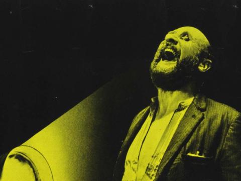 A detail from a Belgian poster for the film Wake in Fright, featuring Donald Pleasence laughing manically with coins from a two-up game covering his eyes