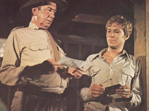 Chips Rafferty and Gary Bond converse in a scene from the film Wake in Fright