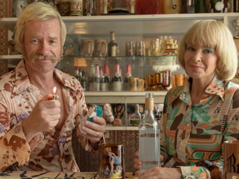 Kylie Minogue and Guy Pearce dressed in 1970s clothing in a production still from Swinging Safari.