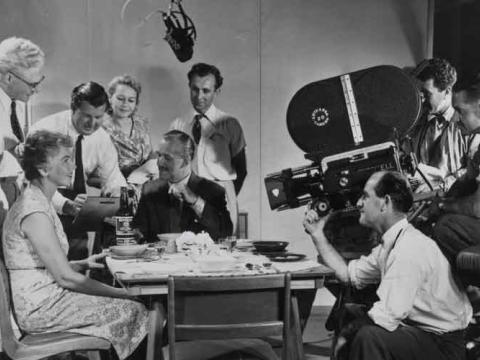 Cast and crew of ten people are filming in a production studio.