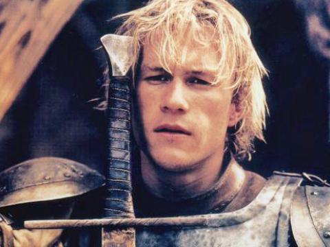 Heath Ledger in a publicity portrait of him as William Thatcher wearing an armour plate and leaning on a sword.