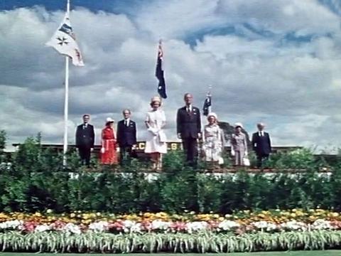 Queen Elizabeth II and Prince Phillip stand facing crowds at an official ceremony during her silver jubilee visit to Australia in 1977.