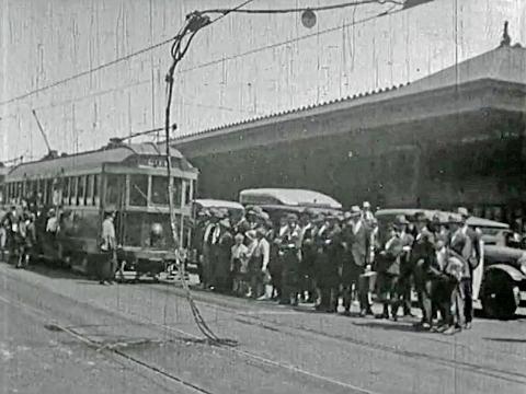 Fused electrical wires cause a tram to break down in Melbourne while people gather to watch. Circa 1920