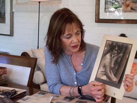 Author Meg Stewart holds a photo of a dress worn in the classic Australian film The Cheaters
