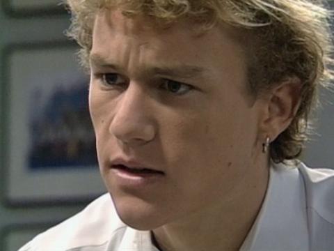 A close-up of Heath Ledger as Scott Irwin in Home and Away. He has bleached blonde hair and an earring in his ear.