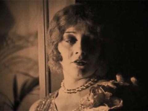 A tear runs down the cheek of Paula Marsh, who has fallen in love with a man from whom she's been stealing, in a scene from silent move The Cheaters