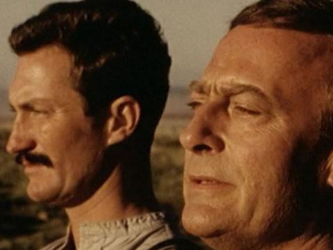 Close up of Edward Woodward and Bryan Brown looking into the sun.