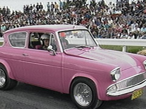 Pink car at the starting line of a race. A large crowd is in the background.