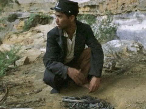 Bradley Byquar crouching in bushland