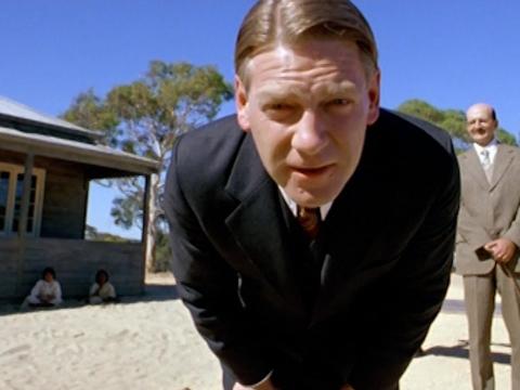 Mr Neville (Kenneth Branagh) leans down peering at Molly (Everyln Sampi)