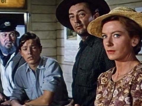 Paddy (Robert Mitchum), Ida (Deborah Kerr), Sean (Michael Andersen Jnr) and Mr Venneker (Peter Ustinov) standing