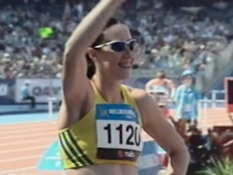 Jana Pittman waves to the crowd while standing at the starting blocks before the women's 400 metre hurdles.