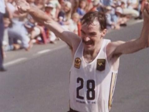Robert de Castella raises his hands in victory as he wins the marathon