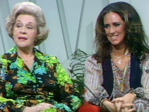 Two women sitting next to each other in a studio.
