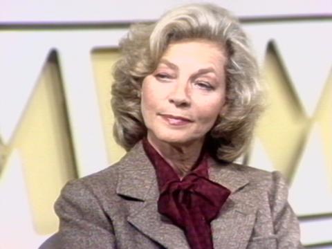 Actor Lauren Bacall sits in a studio. She has a quizical look on her face.