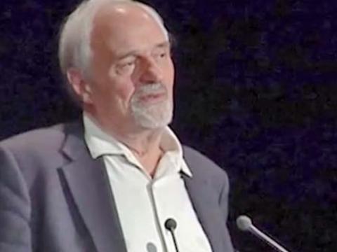 Ted Kotcheff standing behind a lectern