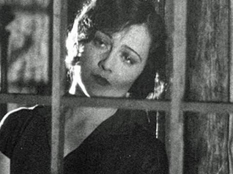 Actress Isabel McDonagh (billed as Marie Lorraine) pictured from the shoulders up,looking from the inside out through a window with her head tilted to the side and a sad look on her face.