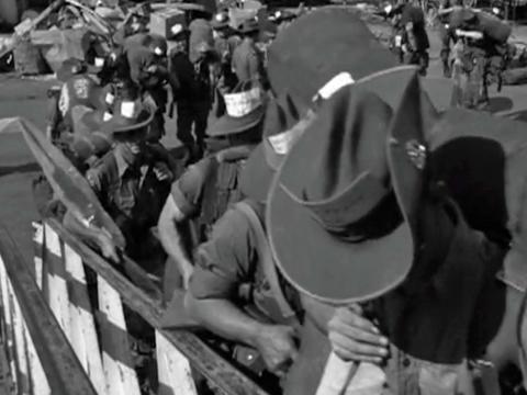 Australian troops in uniform and wearing slouch hats boarding a ship bound for the Vietnam War