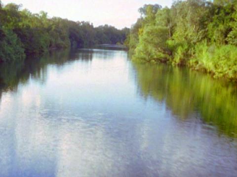 A body of water in central Arnhem Land with lush greenery on the banks.