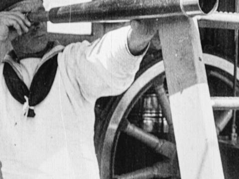 A sailor looks through a telescope