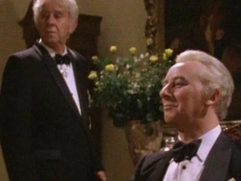 Sir John Kerr (John Meillon) standing and Prime Minister Gough Whitlam (Max Phipps) seated in formal attire