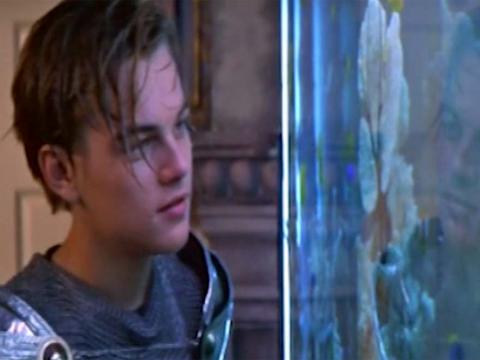 Leonardo DiCaprio as Romeo looks at Juliet through the glass of an aquarium.