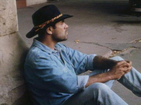 Hugo Hutton (Ben Oxenbould) sits on the ground wearing an stockman's hat