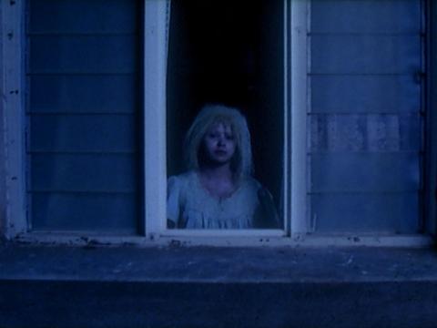 An Indigenous albino girl staring out a window