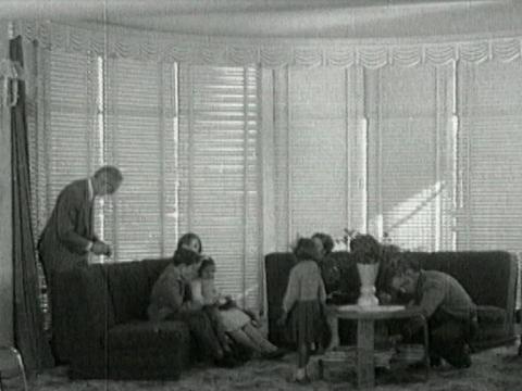 Wide shot of two little Aboriginal girls in the living room of their adopted white family