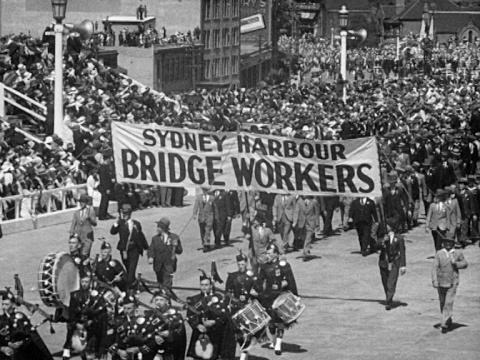 People marching in the parade at the opening of the Sydney Harbour Bridge, a sign reads "Sydney Harbour Bridge Workers"