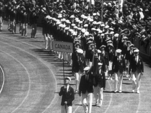 Film still of athletes marching in the stadium for the opening ceremony.